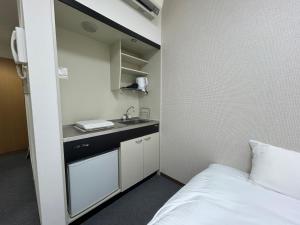 a small bathroom with a sink and a bed at TOMAレジデンスホテル TOMA Residence Hotel in Kure +15 photos