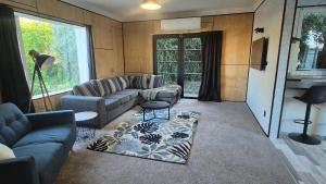 a living room with a couch and a table at Welcome To Wansbeck in Oamaru