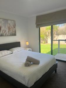 a bedroom with a bed with a towel on it at Boutique Coastal Beach House Cowes Phillip Island Sleeps 8 in Cowes +18 photos