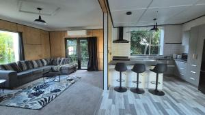 a kitchen and living room with a couch and a table at Welcome To Wansbeck in Oamaru