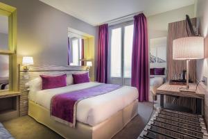 a hotel room with a large bed with purple pillows at Louvre Marsollier Opera in Paris