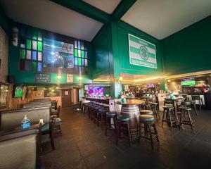 a bar with bar stools and a green wall at O'Shea's Sukhumvit Bangkok in Klong Toi