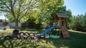 a playground with a slide and a play structure at Kun Kuckó Vendégház in Kiskunmajsa