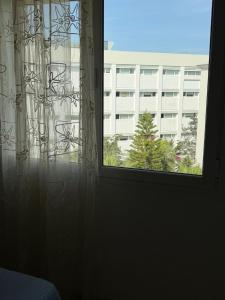 a bedroom window with a view of a building at Lac 2 Tunisi in El Aouina Station