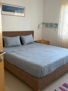 a bedroom with a large bed with blue sheets at Lac 2 Tunisi in El Aouina Station