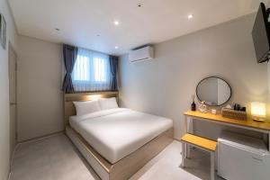a small bedroom with a white bed and a mirror at BigBoxStay Myeongdong in Seoul +65 photos