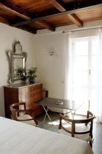 1 dormitorio con escritorio, mesa y ventana en Locanda Tramonti, en La Spezia