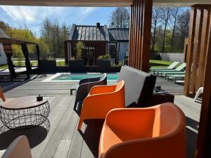 a patio with chairs and a table and a pool at Leśna Polana Domki in Okuninka