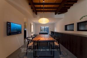 a dining room with a large wooden table and chairs at Experience Ise Miyamachi Hotel in Ise