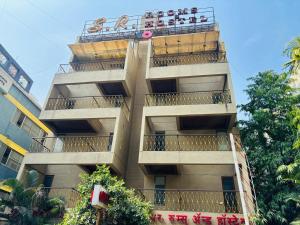 a tall building with a sign on top of it at S R Rooms in Pune