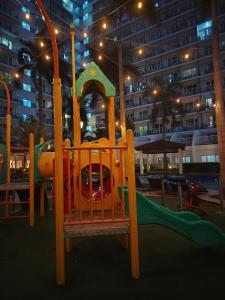 a playground with a slide in a park at night at Lamierda Condotel 2 in Iba