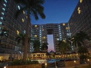a hotel with a pool in front of two tall buildings at Lamierda Condotel 2 in Iba