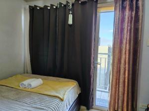 a bedroom with a bed and a window with curtains at Lamierda Condotel 2 in Iba +20 photos