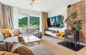 a living room with a couch and a fireplace at Awesome Apartment In Strandebarm in Strandebarm