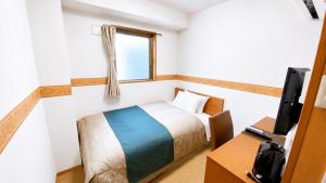 a small bedroom with a bed and a television at レックスインなんば in Osaka