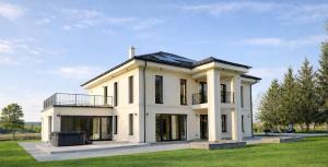 a white house with a balcony on a lawn at Berek Kúria in Sonkád
