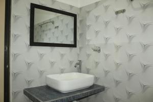 a bathroom with a white sink and a mirror at The LeoEye Wilpattu in Pahala Maragahawewa +21 photos