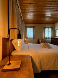 a bedroom with a large bed with a lamp on it at Apokas Country House in Zoopiyi +50 photos