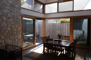 a dining room with a table and some glass doors at Camelot in Kingscote