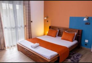 a bedroom with a bed with orange and blue walls at confortable calme , wifi gratuit in Antananarivo