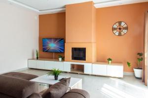 a living room with a couch and a clock on the wall at confortable calme , wifi gratuit in Antananarivo