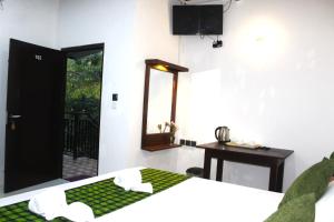 a room with a bed and a table and a mirror at The LeoEye Wilpattu in Pahala Maragahawewa