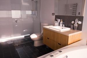 a bathroom with a toilet and a sink and a shower at Camelot in Kingscote +26 photos