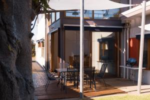 a patio with a table and chairs and an umbrella at Camelot in Kingscote