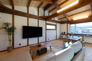 a living room with a couch and a flat screen tv at nikko nagomi 和み in Nikko