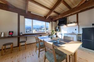 a kitchen with a table and chairs and a large window at nikko nagomi 和み in Nikko