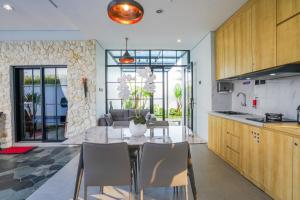 a kitchen and dining room with a table and chairs at The Lavana Infinity Jogja Villa in Salakan