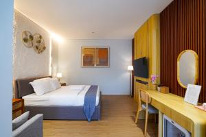 a hotel room with a bed and a desk at The Lavana Infinity Jogja Villa in Salakan +61 photos