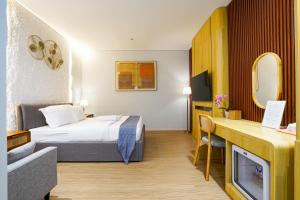 a hotel room with a bed and a tv at The Lavana Infinity Jogja Villa in Salakan