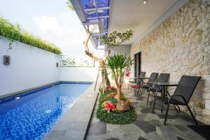 a swimming pool with a table and chairs next to it at The Lavana Infinity Jogja Villa in Salakan