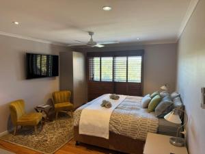 a bedroom with a large bed and two chairs at Sinclairs Country Retreat - Welcoming Guests 18 years and older in Conjola