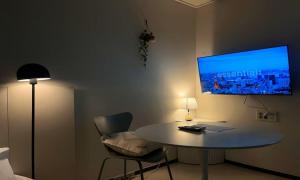 a room with a table and a tv on the wall at Yeonsan The Stay in Busan