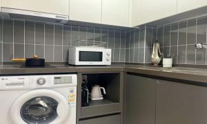 a kitchen with a washing machine and a microwave at Yeonsan The Stay in Busan