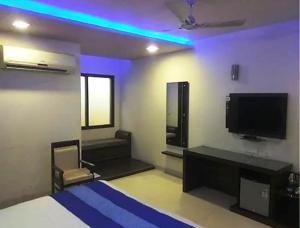 a bedroom with a bed and a tv and a couch at ToBo Retreat Agra Taj Mahal in Agra