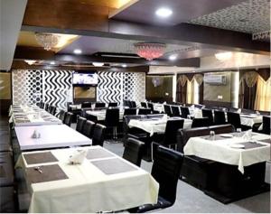 a dining room with white tables and black chairs at ToBo Retreat Agra Taj Mahal in Agra