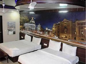 two beds in a room with a picture of a city at ToBo Retreat Agra Taj Mahal in Agra
