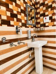 a bathroom with a sink and a mirror at Athiti Devo Bhava in Chakrāta