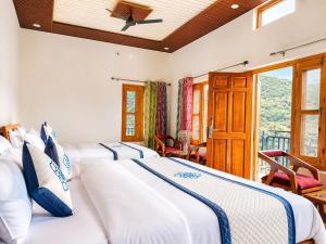 a bedroom with two beds and a balcony at Athiti Devo Bhava in Chakrāta