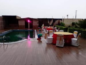 a group of tables and chairs next to a pool at ToBo Retreat Agra Taj Mahal in Agra
