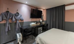 a hotel room with a bed and a desk at Cheongju Hotel Dictionary in Cheongju