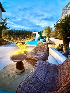 a patio with two chairs and a table and trees at Casa de oro Alma in Sozopol
