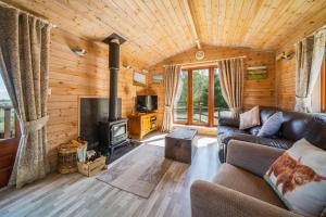 a living room with a couch and a stove at Ewe Lodge in Ashbourne