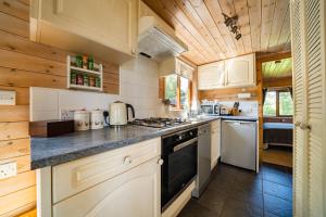 a kitchen with white appliances and wooden ceilings at Ewe Lodge in Ashbourne