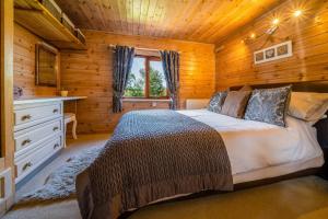 a bedroom with a bed in a wooden cabin at Ewe Lodge in Ashbourne