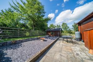 a patio with a table and chairs and a barn at Ewe Lodge in Ashbourne