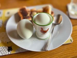 a plate with eggs and a cup on a table at Ewe Lodge in Ashbourne +9 photos